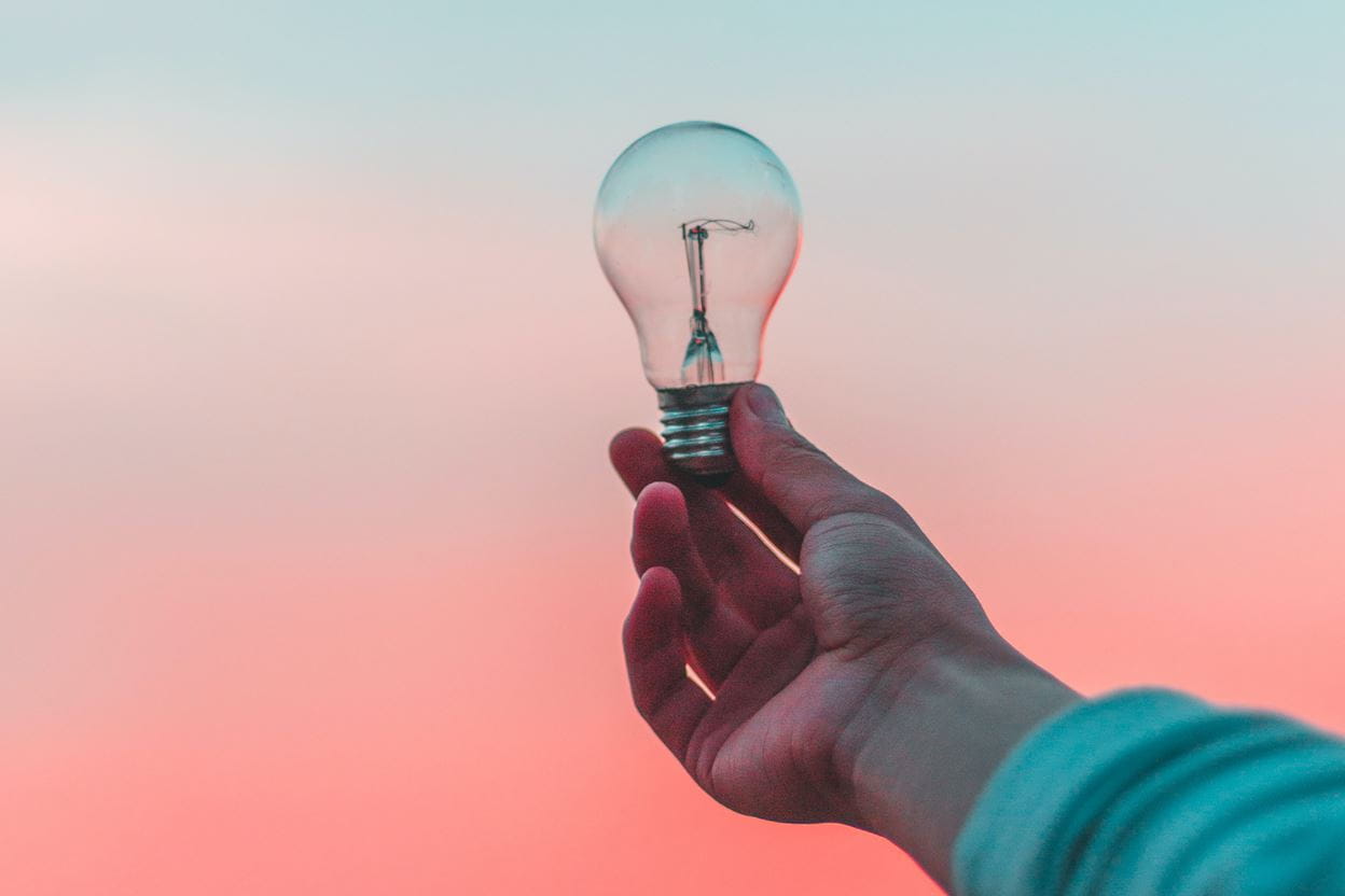 Someone holding a light bulb