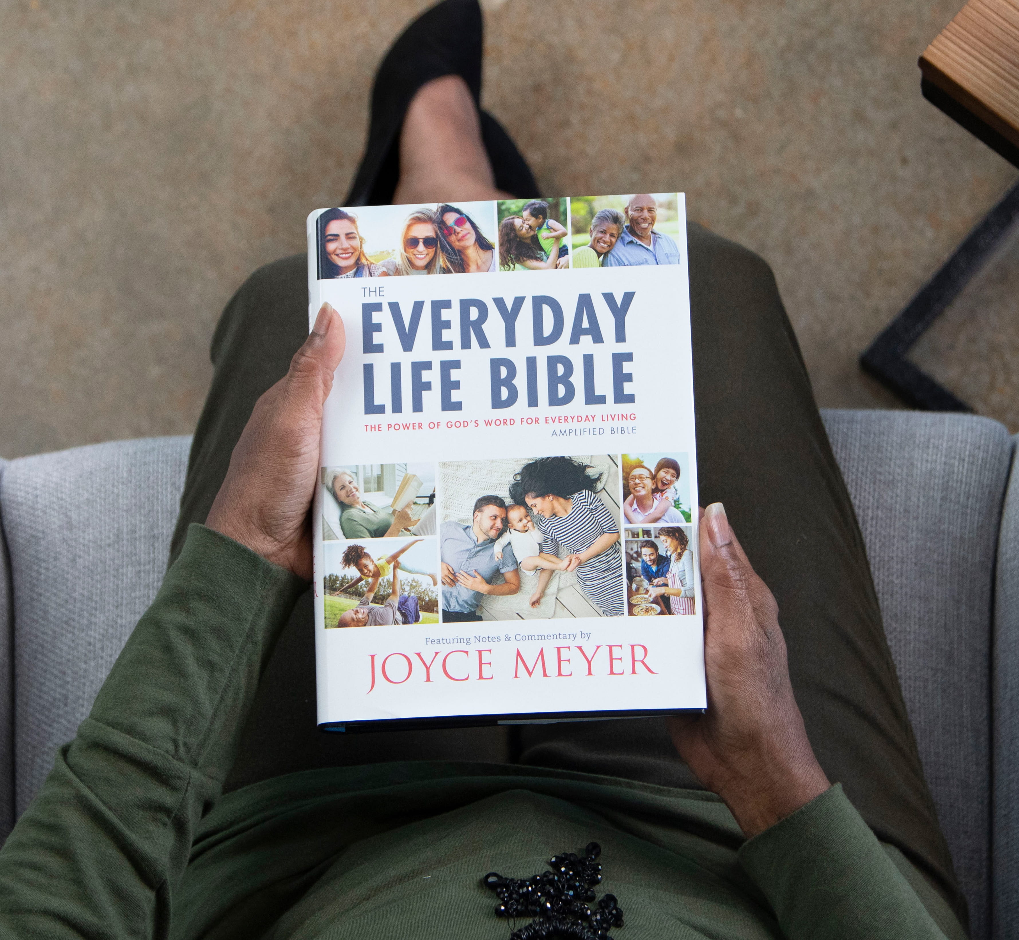 The Everyday Life Bible being held by a woman sitting on her lap. 